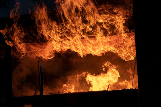 Bright flames engulfing a structure, creating a dramatic and intense fire scene.